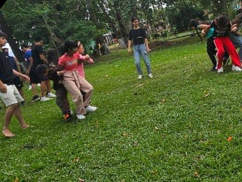 Participantes en movimiento durante un juego sobre el césped de un parque